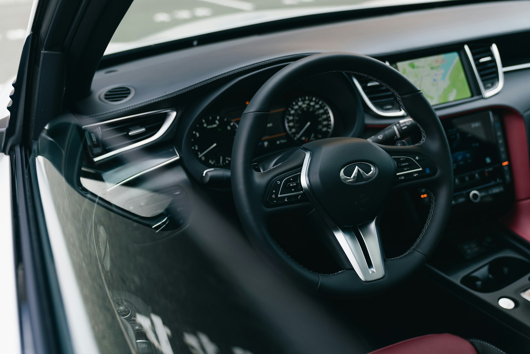 The front cabin of a modern SUV, showing the steering wheel, navigation screen and leather seats. Illustrative photography — not a vehicle held, offered for sale, or priced by Automotive Car Brokers.
