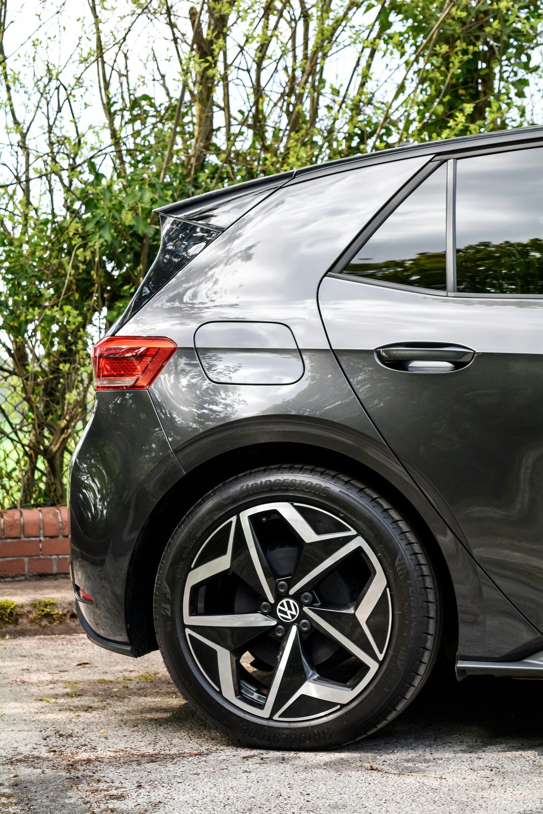 A close view of the rear wheel and haunch of a gray hatchback. Illustrative photography — not a vehicle held, offered for sale, or priced by Automotive Car Brokers.